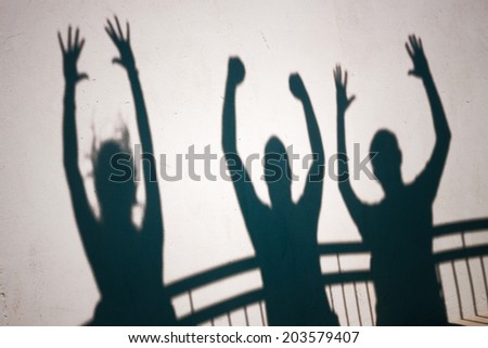 Creative photo of ecstatic people shadows on white wall