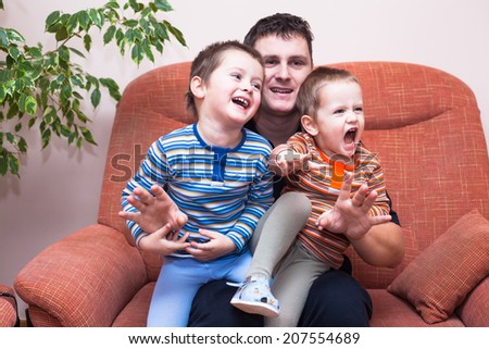 Happy children boys and daddy having fun on sofa at home