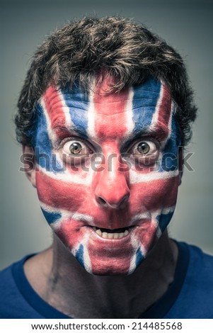 Portrait of spooky man with British flag painted on face.