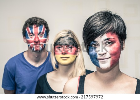 Portrait young people with painted European flags on their faces.