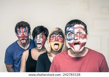 Group of funny people with painted flags on their faces and sticking out tongue.