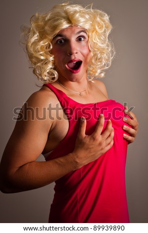 man dressed as a woman holding his breasts - stock photo