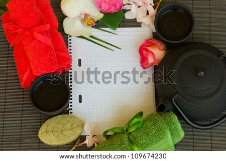 asian tea set and spa settings with blank note book on bamboo mat