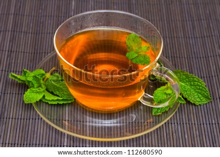 tea cup with mint on black bamboo mat