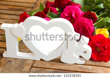 love sign with  roses on wooden table - copy space