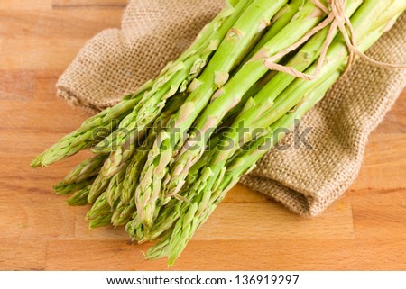 fresh green asparagus sprouts in pouch   on wooden table