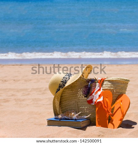 sunbathing accessories on sandy beach by the ocean