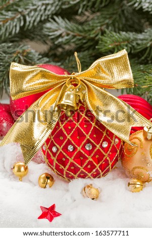 red  and gold christmas ball with bow in snow