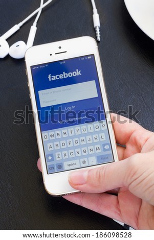 WARSZAWA, POLAND - APRIL 01, 2014: Loging in Facebook app on Iphone5s with help of finger print. Facebook the largest social network in the world.