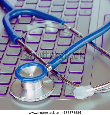 stethoscope on laptop keyboard - modern medicine concept