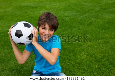 smiling handsome teenager boy holding football ball
