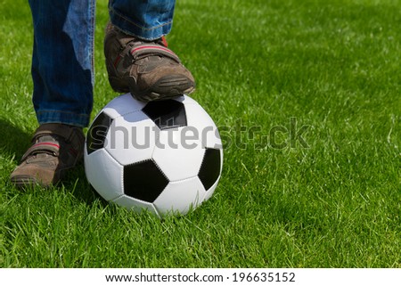 close up of foot and football ball on green grass background