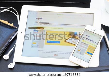 WARSZAWA, POLAND - APRIL 17, 2014.  Paypal internet page on screen of ipad and Iphone 5s. PayPal is a popular and international method of money transfer via the Internet.