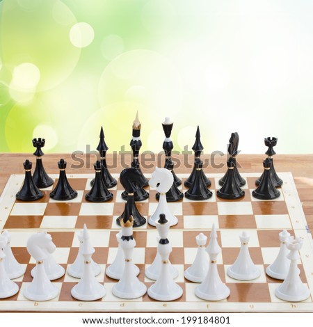 set of chess ready to play on green garden bokeh background