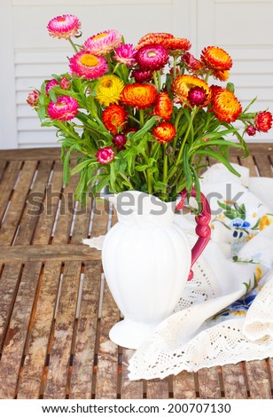 Bouquet of Everlasting flowers bouquet in vase  on wooden table