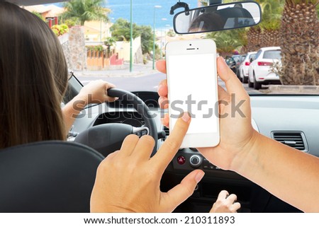 hands holding a touch phone with empty  screen on a background woman driving a car