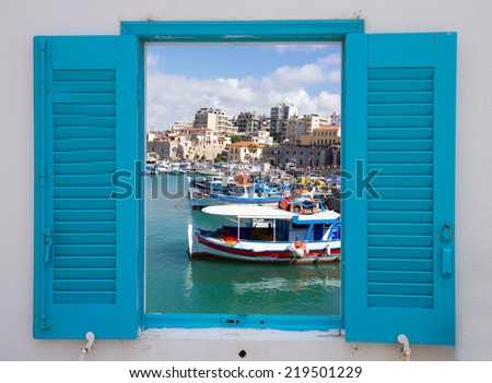 window with view of Heraklion old port with colorful boats, at sunny day, Crete, Greece