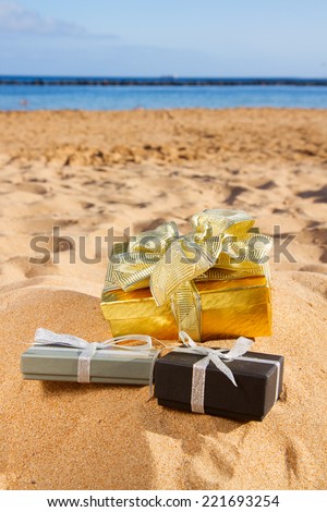 pile of christmas gifts on beach  with golden sand at sunny day