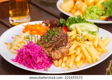 plate of  meat steak , french fries and red pricled  cabbage
