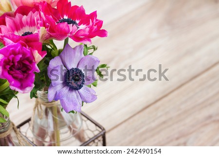 mauve and blue  anemone  flowers  in vase   on table with copy space