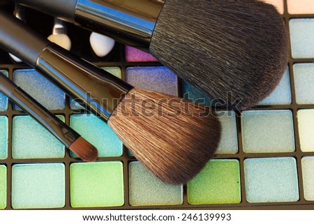 set of  brushes on colorful  eye shadows palette