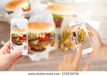 someones hands with mobile phone making  photo of hamburgers