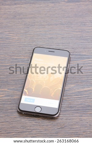 WARSZAWA, POLAND - DECEMBER 16, 2014.  Apple Iphone 6 in gray space black color with twitter page on screen laying on wooden table. Twitter is one of the largest social media web site.