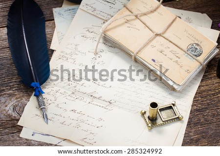 pile of  antique letters and blue  feather pen