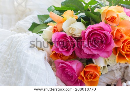 pink and orange roses on white lace background