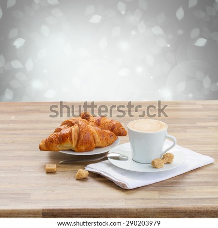 white cup with fresh espresso  coffee and croissant on gray background