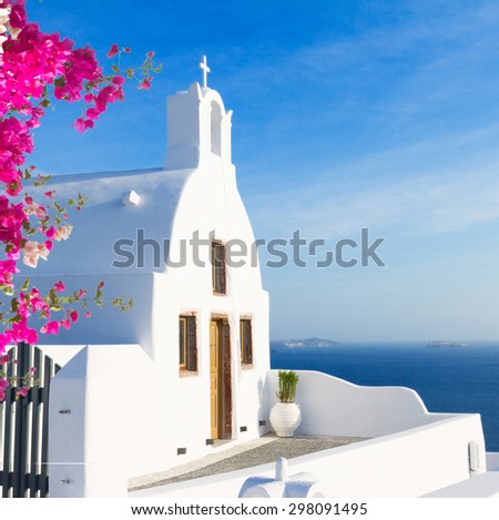beautiful details of Santorini island - typical house with white walls, pink flowers  and blue sea Greece