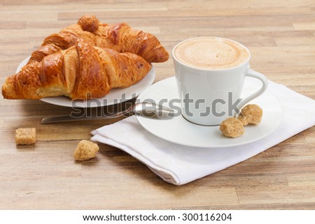 white cup with fresh espresso  coffee with water and croissant