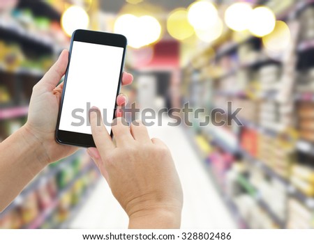 someones  hands holding mobile smart phone with empty screen  on supermarket blur background business concept
