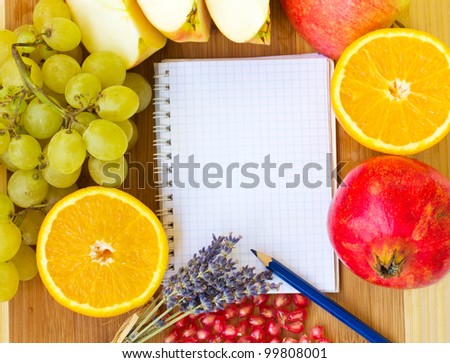 notebook for recipes with fresh  fruits on wooden background