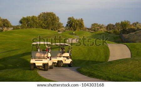 Two golf carts stand on the course path beside the ninth hole mature sport
