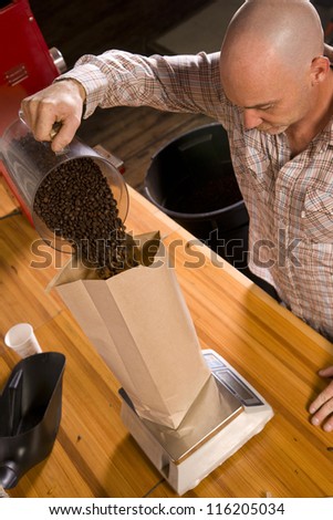An experienced coffee roaster bags up his finished product packaged beans for sale