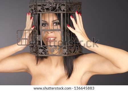 Bird cage offers an interesting frame for beautiful brunette woman
