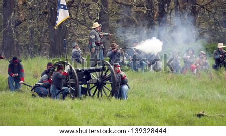 STEILACOOM, WASHINGTON/USA - MAY 1: Civil War Reenactment cannoneers rest between firing while infantry fire rifles May 1, 2010.