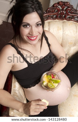 Beautiful woman 8 months plus pregnant eating lunch fresh fruit