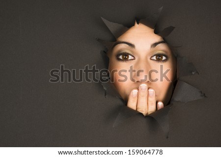 Beautiful Brunette Woman Looks Through Torn Hole Hand Covers Mouth