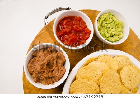 Food Appetizers Chips and Salsa Refried Beans Guacamole on Wood Cutting Board