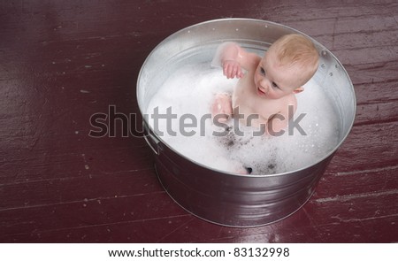 6 month old Boy bathing in a galvanized tub child frolics in bubble bath