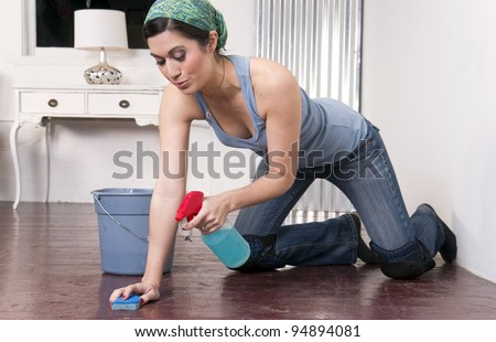 A housekeeper on her knees washing the floor the old fashioned way