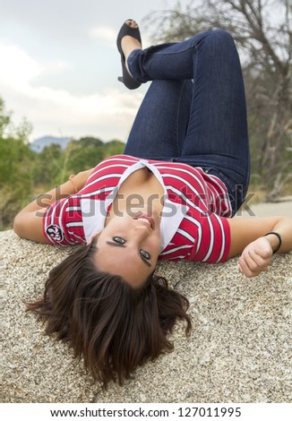 beautiful young woman lying on her back with head hanging back and loose hair
