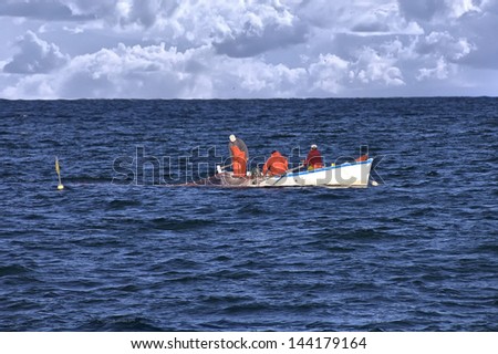 fishermen fishing in the sea in a small boat