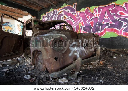 House destroyed with burned car and very colorful graffiti