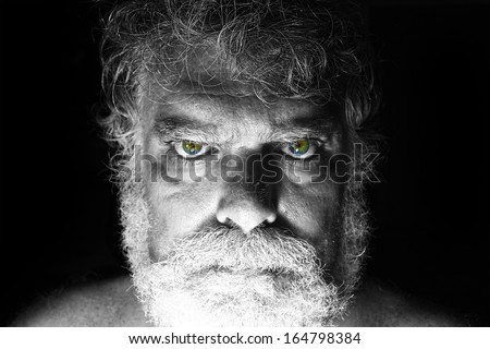 Mature bearded man with angry face staring