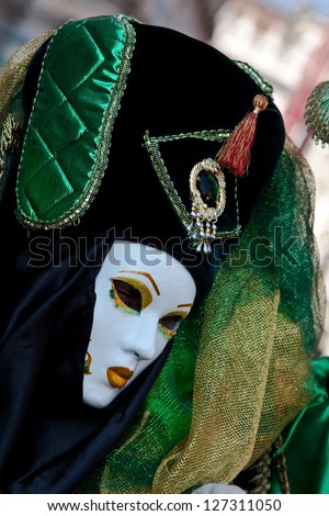 VENICE - FEBRUARY 18: Unidentified woman masks at St. Mark\'s Square participate in the Carnival of Venice on February 18, 2012. The annual carnival is from February 4 to February 21, 2012.
