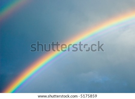 colorful rainbow in dark gray sky
