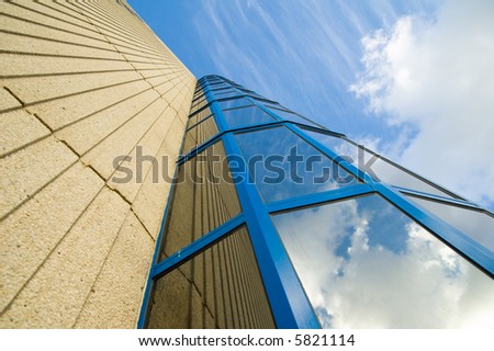 blue sky with white clouds reflecting in modern architecture tower building